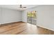 Bedroom with wood flooring and sliding glass doors leading to a screened patio at 4447 Brook Hollow Cir, Winter Springs, FL 32708