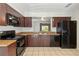 Well-lit kitchen with tile flooring, stainless steel appliances, and dark wood cabinets at 4447 Brook Hollow Cir, Winter Springs, FL 32708
