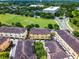 Aerial view of a neighborhood with tan condos, green space, parking lots, and surrounding trees at 4562 Lower Park Rd, Orlando, FL 32814