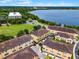 An aerial of tan condos with terracotta roofs, green space, and a lake at 4562 Lower Park Rd, Orlando, FL 32814