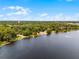 Scenic aerial of lakefront property surrounded by lush greenery and distant city skyline at 4562 Lower Park Rd, Orlando, FL 32814