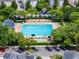 Aerial shot of a pristine pool surrounded by trees and lounge chairs, set in a residential neighborhood at 4562 Lower Park Rd, Orlando, FL 32814
