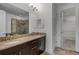 Bathroom with granite countertops, double sinks, dark wood cabinets and a tiled shower at 4562 Lower Park Rd, Orlando, FL 32814