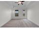 Spacious bedroom boasts natural light, neutral carpet, and a tray ceiling with fan at 4562 Lower Park Rd, Orlando, FL 32814