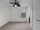 Bright carpeted bedroom featuring a ceiling fan, a large window, and an ensuite bathroom at 4562 Lower Park Rd, Orlando, FL 32814