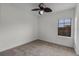 Cozy bedroom with neutral carpet, ceiling fan, and a window offering natural light in the living space at 4562 Lower Park Rd, Orlando, FL 32814