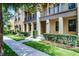 Charming townhome featuring manicured landscaping, a covered porch, and second story balcony at 4562 Lower Park Rd, Orlando, FL 32814