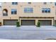 Row of townhome garages showcasing uniform design and landscaping within a residential neighborhood at 4562 Lower Park Rd, Orlando, FL 32814