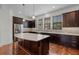 Spacious kitchen with a large island, dark cabinets, stainless steel appliances, and hardwood floors at 4562 Lower Park Rd, Orlando, FL 32814