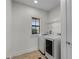Bright laundry room has tile floors, wire rack shelving, and modern washer and dryer at 4562 Lower Park Rd, Orlando, FL 32814