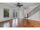 Bright living room with hardwood floors, a ceiling fan, and access to the staircase and balcony at 4562 Lower Park Rd, Orlando, FL 32814