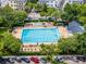 A large community pool is surrounded by lounge chairs and lush landscaping from an aerial view at 4562 Lower Park Rd, Orlando, FL 32814