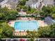 Aerial view of a community pool surrounded by lounge chairs, tables, umbrellas, and manicured landscaping at 4562 Lower Park Rd, Orlando, FL 32814