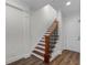 Elegant staircase featuring hardwood stairs, a black iron railing, and white trim at 4562 Lower Park Rd, Orlando, FL 32814