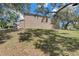 Grassy backyard view of home showcasing landscaping, mature trees, and a tranquil setting at 503 Portland Cir, Apopka, FL 32703