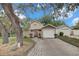 Charming home exterior featuring a well-manicured lawn, driveway, mature trees and single car garage at 503 Portland Cir, Apopka, FL 32703