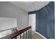 Upstairs hallway with wood railing and gray carpet that leads to a white door at 503 Portland Cir, Apopka, FL 32703