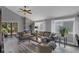 Open living room with an adjacent dining area features large windows, high ceiling, and ceiling fan at 503 Portland Cir, Apopka, FL 32703