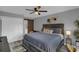Inviting main bedroom with light gray walls, ceiling fan, with a hallway view to bathroom at 503 Portland Cir, Apopka, FL 32703