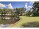 Picturesque view of pond with reflective water and lush green shoreline, ideal for relaxation and enjoying nature at 503 Portland Cir, Apopka, FL 32703