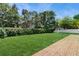 Private backyard with a lush lawn, mature trees, brick patio, and white fence at 5130 Sun Palm Dr, Windermere, FL 34786