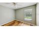 Cozy bedroom with wood-look floors, neutral paint, and a bright window with outdoor views at 5130 Sun Palm Dr, Windermere, FL 34786