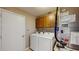Convenient laundry room featuring a washer, dryer, overhead cabinets, and utility closet at 5130 Sun Palm Dr, Windermere, FL 34786