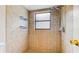 This tiled shower features updated fixtures, inset shelves, and a window for natural light at 5130 Sun Palm Dr, Windermere, FL 34786
