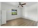 Bright, empty bedroom with laminate flooring, ceiling fan, and large window at 563 Belltower Ave # 240, Deltona, FL 32725