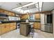Well-equipped kitchen with island, stainless steel appliances, and natural wood cabinets at 563 Belltower Ave # 240, Deltona, FL 32725