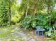 Secluded backyard garden area with a charming patio set surrounded by lush greenery and mature trees at 660 Neile Ct, Oviedo, FL 32765
