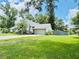 Side view of a well-maintained home with a green lawn, mature landscaping, and a fenced-in yard at 660 Neile Ct, Oviedo, FL 32765