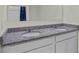 Double vanity with granite countertop, white cabinets, and modern faucets provides a luxurious feel at 7112 Mottled Duck Dr, Harmony, FL 34773
