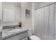 Neutral bathroom with granite countertop, framed mirror, and shower curtain at 7112 Mottled Duck Dr, Harmony, FL 34773