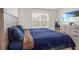 Bright bedroom with a large bed, dresser, natural light, and a view of the landscaped yard at 7112 Mottled Duck Dr, Harmony, FL 34773