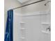 Clean, white shower with built-in shelves and a chrome shower head, paired with a blue fabric shower curtain at 7112 Mottled Duck Dr, Harmony, FL 34773