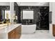 Luxurious bathroom with marble floors, a modern vanity, soaking tub, and designer black marble tile at 7733 Pointe Venezia Dr, Orlando, FL 32836