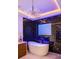 Stylish bathroom featuring a standalone tub, a TV, and marble tiled walls at 7733 Pointe Venezia Dr, Orlando, FL 32836