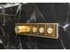 Close up of elegant shower controls finished in gold, set against a black marble tiled wall at 7733 Pointe Venezia Dr, Orlando, FL 32836