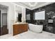 Luxurious bathroom with a double vanity, black marble accents, a modern soaking tub, and designer lighting at 7733 Pointe Venezia Dr, Orlando, FL 32836
