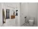 Elegant bathroom featuring marble floors, modern fixtures, walk-in closet, and adjacent water closet at 7733 Pointe Venezia Dr, Orlando, FL 32836