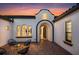 Welcoming courtyard entrance with brick pavers, stylish seating, and a charming stucco exterior at twilight at 7733 Pointe Venezia Dr, Orlando, FL 32836