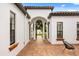 Exterior courtyard with wrought-iron gate, brick pavers, and white stucco walls with dark trim at 7733 Pointe Venezia Dr, Orlando, FL 32836