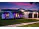 Charming home at twilight with lush landscaping, a tile roof, and illuminated palm trees at 7733 Pointe Venezia Dr, Orlando, FL 32836