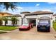Attractive house with landscaped lawn and an array of luxury vehicles parked in the driveway and garage at 7733 Pointe Venezia Dr, Orlando, FL 32836