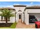 Close up of a house with a tile roof, landscaped lawn, luxury vehicle and gated entry at 7733 Pointe Venezia Dr, Orlando, FL 32836