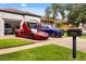 Attractive house with landscaped lawn and an array of luxury vehicles parked in the driveway and garage at 7733 Pointe Venezia Dr, Orlando, FL 32836