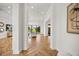 Elegant hallway featuring herringbone wood floors, white walls, and views of the outdoor living space at 7733 Pointe Venezia Dr, Orlando, FL 32836