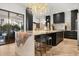 Kitchen with a large island with seating, modern appliances and lighting, and dark cabinetry at 7733 Pointe Venezia Dr, Orlando, FL 32836