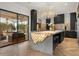 Modern kitchen featuring a unique, illuminated kitchen island, dark cabinets, and stylish chandelier at 7733 Pointe Venezia Dr, Orlando, FL 32836